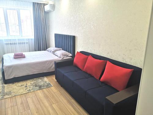 a living room with a couch and a bed at Уютная квартира в ЖК Bir Group Актобе in Aktobe