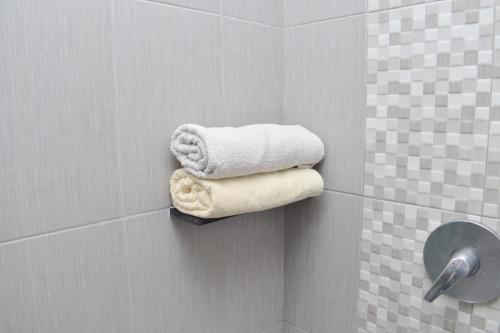 a bathroom with towels on a wall in a shower at Homestay 82 Syariah Palembang in Palembang