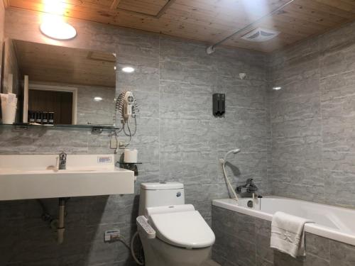a bathroom with a toilet and a sink and a tub at Unite Hotel in Taipei