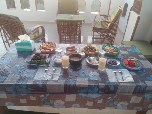 a table with a table cloth with food on it at Tasneem Palace in Luxor