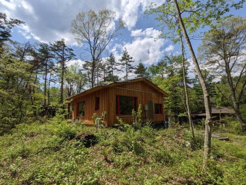 a small wooden cabin in the middle of a forest at Kartoffel in Kita-karuizawa
