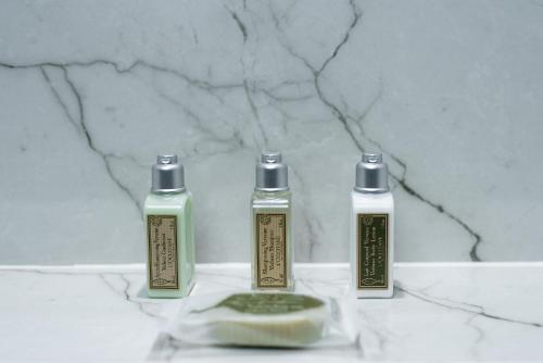 three bottles of mouthwash sitting on a marble counter at Hotel Holiday International in Sharjah