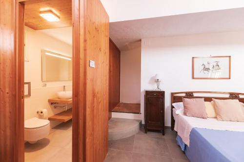 a bedroom with a bed and a bathroom with a sink at Villa Le Lune in Santa Margherita di Belice