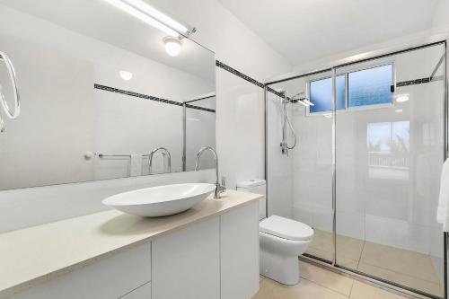 a white bathroom with a sink and a toilet at 3 41 Tingira Crescent Sunrise Beach in Sunrise Beach