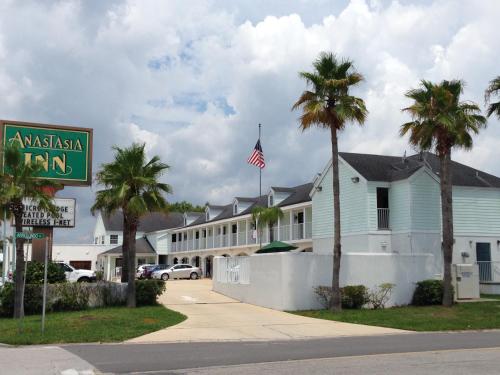 a street view of a inn with palm trees and a sign at Anastasia Inn - Saint Augustine in Saint Augustine
