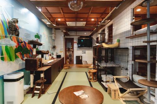 a room with tables and chairs and a tv at Cat Spa & Cat Ryokan by Neco Republic Osaka in Osaka