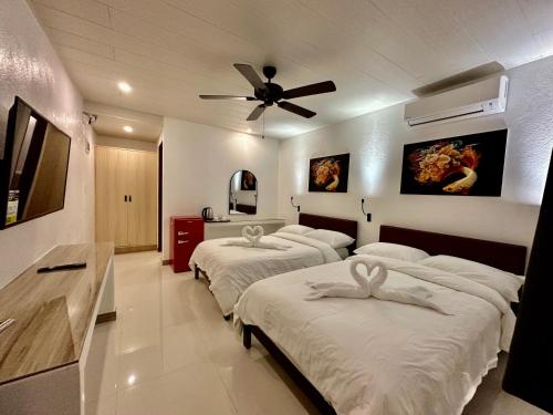 Ліжко або ліжка в номері Calypso Beach and Dive Resort