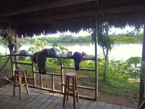 a person sleeping at a table with two bar stools at Tambopata River in Puerto Maldonado