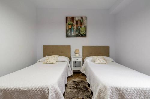 ポテスにあるApartamento Valverde IIの白い壁の客室内のベッド2台