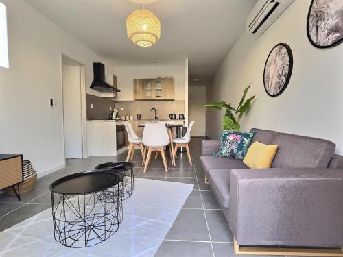 ein Wohnzimmer mit einem Sofa und einem Tisch in der Unterkunft Maison calme-golf in Montboucher-sur-Jabron