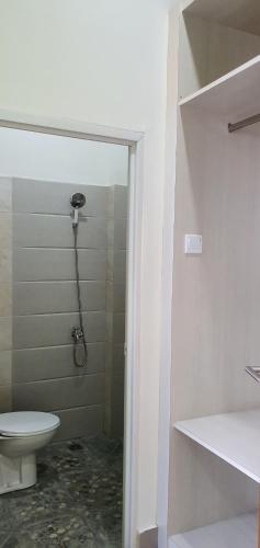y baño con aseo y ducha. en REG GUESTHOUSE en Tanjungredep