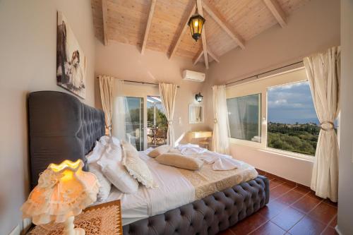 a bedroom with a large bed with a large window at Villa Socrates in Skala