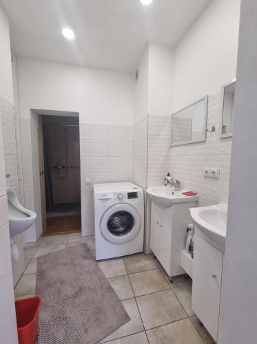 a white bathroom with a washing machine and a sink at Gedimino g. 2 in Mažeikiai
