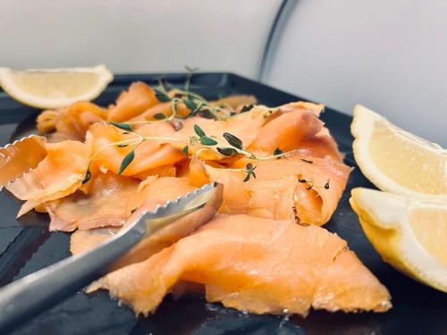 ホニングスヴォーグにあるArctic Boutique Hotel Northcapeのフォークとレモンスライスが添えられた魚の皿