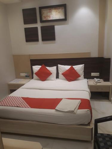 a bedroom with a large bed with red pillows at Hotel MEGHA INN in Lucknow