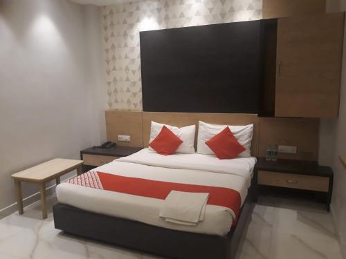 a hotel room with a large bed with red pillows at Hotel MEGHA INN in Lucknow