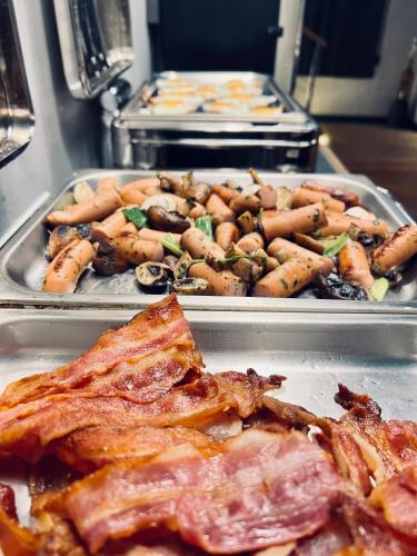 ホニングスヴォーグにあるArctic Boutique Hotel Northcapeの肉とキノコが入った2つの金属製のトレイ