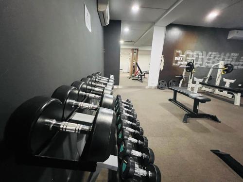 a gym with rows of dumbbells in a room at HANA Stay Riverside in Hanoi