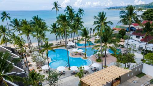 - une vue aérienne sur la piscine et la plage du complexe dans l'établissement Outrigger Koh Samui Beach Resort - SHA Extra Plus, à Lamai