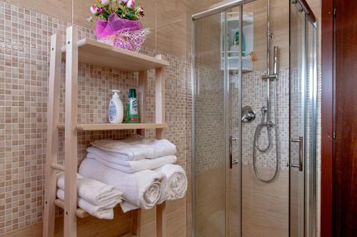 a bathroom with a shower and a bunch of towels at Casina di Liliana in Livorno