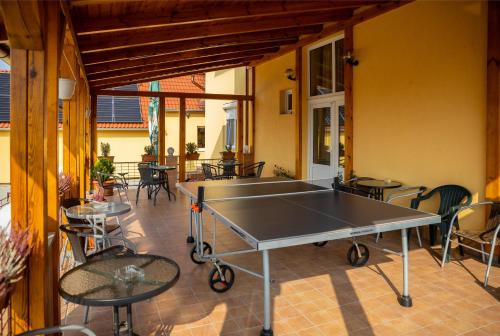 un tavolo da ping pong su un patio con tavoli e sedie di Betli Panzió a Zalaegerszeg