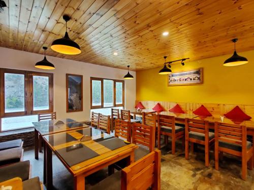 a dining room with wooden tables and chairs at Prakriti-The Retreat in Gangotri