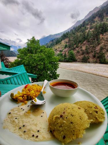 a plate of food with a bowl of salsa and a bowl of food at Prakriti-The Retreat in Gangotri