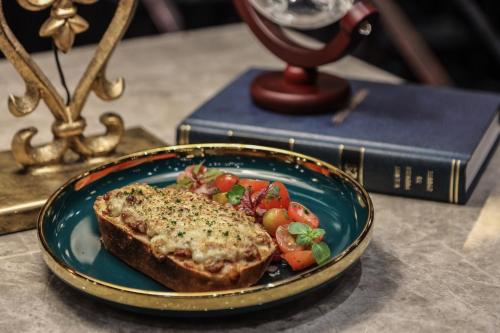 a plate of food with a piece of bread and vegetables at The Coach Hotel Sukhumvit - Asok BTS Bangkok in Bangkok
