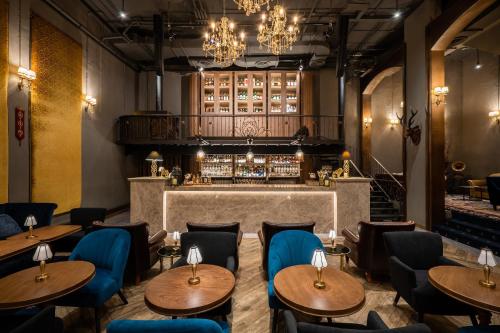 a restaurant with wooden tables and chairs and a bar at The Coach Hotel Sukhumvit - Asok BTS Bangkok in Bangkok