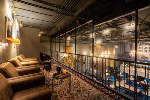 a room with couches and a balcony with lights at The Coach Hotel Sukhumvit - Asok BTS Bangkok in Bangkok
