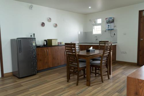 a kitchen with a table and chairs and a refrigerator at Regal Suites in Bengaluru