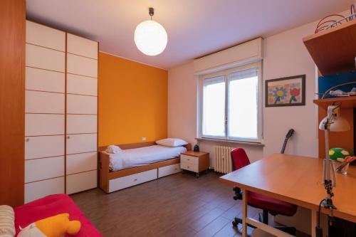 um quarto com uma cama, uma secretária e uma mesa em [Buccinasco apartment] Mascherpa em Buccinasco