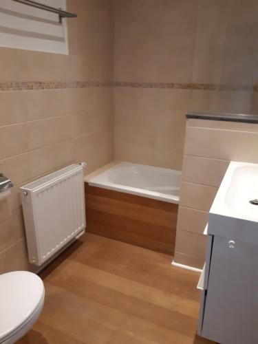 a bathroom with a tub and a toilet and a sink at Maison cosy au centre de Nivelles in Nivelles