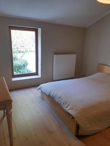 una camera con un grande letto e una finestra di Maison cosy au centre de Nivelles a Nivelles