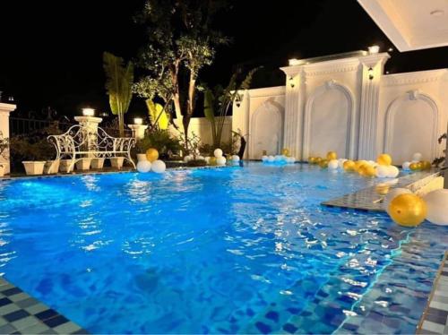 uma piscina com bolas na água à noite em Villa Blueware - Venuestay em Vĩnh Phúc