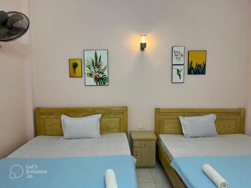 two beds sitting next to each other in a room at Cat Ba Sweet Potato Homestay in Cat Ba
