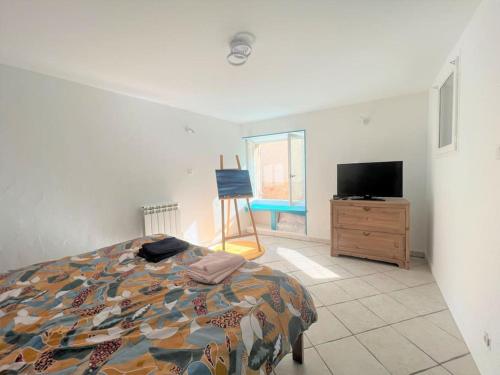 une chambre avec un lit et une télévision à écran plat dans l'établissement charmant meublé dans un joli village circulaire, à Alixan