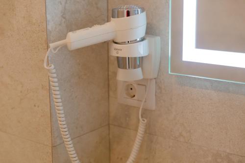 a hair dryer is attached to a wall in a bathroom at Muller Hotel Boutique & Spa in Galaţi