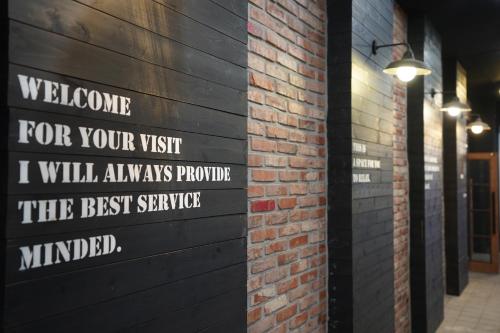 a sign on the side of a brick wall at 27 Hotel in Anyang