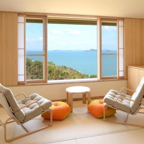 a room with two chairs and a table and windows at Kyukamura Setouchi-Toyo in Saijo