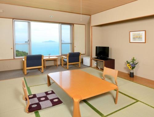 uma sala de estar com mesa e cadeiras em Kyukamura Setouchi-Toyo em Saijo
