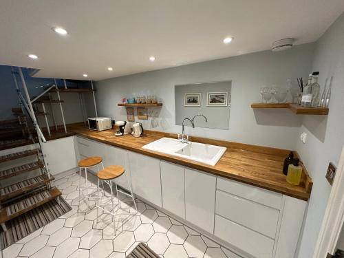 a kitchen with a sink and a counter with stools at The Beetroot in Margate