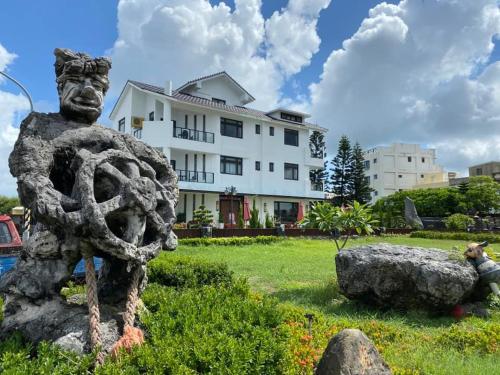 a statue of a man in a yard with a building at Ocean View Hall B&B in Magong