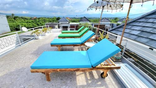 a group of blue chairs and an umbrella on a roof at Villa Mosel Bali in Banjar