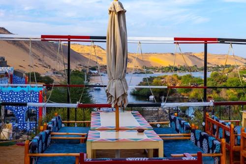 a patio with a table and an umbrella on a boat at Onaty Ka Guest House in Aswan