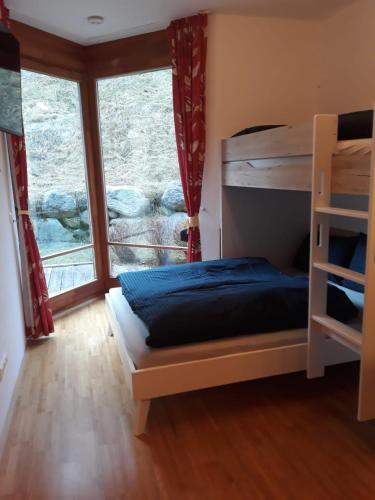 sypialnia z łóżkiem piętrowym i dużym oknem w obiekcie Ferienappartment in St Oswald - Bad Kleinkirchheim Nähe der Skipiste w mieście Obertschern