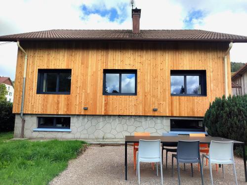 une table et des chaises devant une maison dans l'établissement Gite le pré des cerfs II, à La Bresse