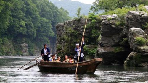 a group of people in a boat on a river at Kyukamura Oku-Musashi in Hanno