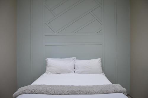een bed met witte lakens en kussens in een kamer bij Accommodation Front - Deluxe 6 Sleeper with Rooftop Pool in Durban
