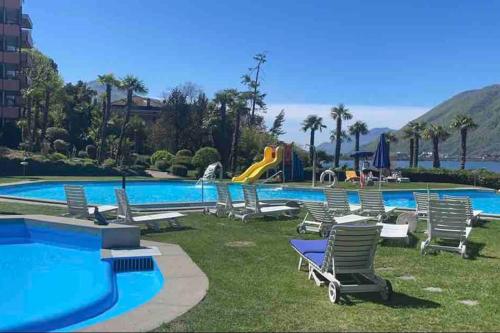 a pool with chaise lounge chairs and a water park at Appartamento con piscina e sauna Bissone in Bissone